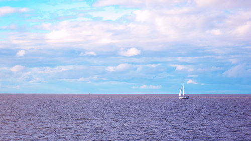 Sailboat sailing on sea against sky