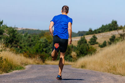 Rear view of man walking on field