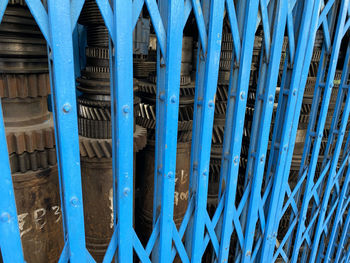 Close-up of blue metallic sliding gate structure against building