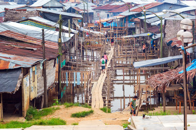 Footbridge amidst stilt houses over river