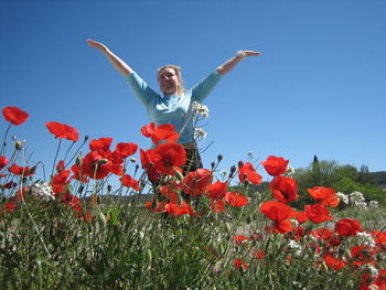 Low angle view of boy jumping on field against clear sky