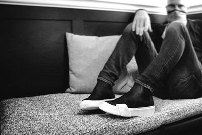 Close-up of man sitting on sofa at home