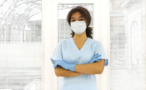 Portrait of young woman standing in hospital