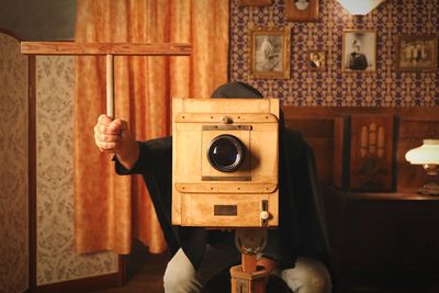 Person photographing with vintage camera at studio