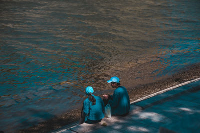High angle view of people sitting at sea shore
