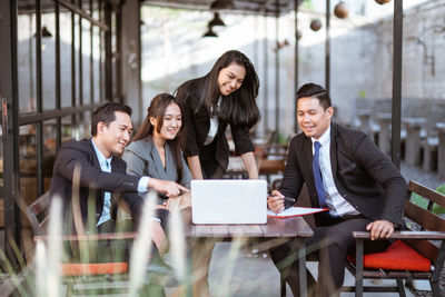 Portrait of smiling businesswoman using laptop while sitting in cafe