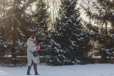 A girl in warm winter clothes walks in nature in the snow. mindfulness concept