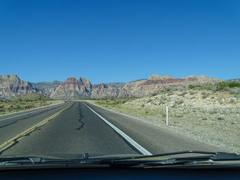 Road against sky seen through car windshield