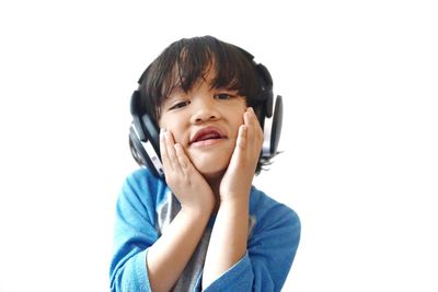 Cute boy listening music against white background