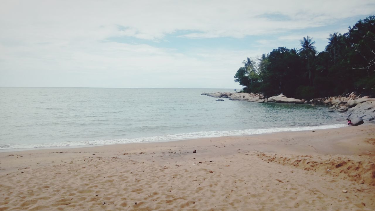 beach, sea, sand, water, shore, horizon over water, sky, tranquil scene, tranquility, scenics, beauty in nature, nature, coastline, wave, tree, idyllic, day, surf, outdoors, vacations