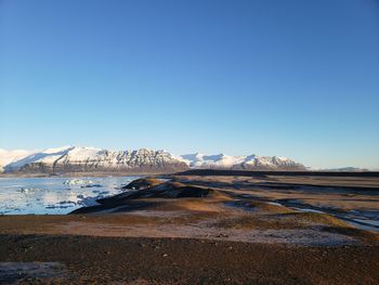 Scenic view of snowcapped mountains against clear blue sky