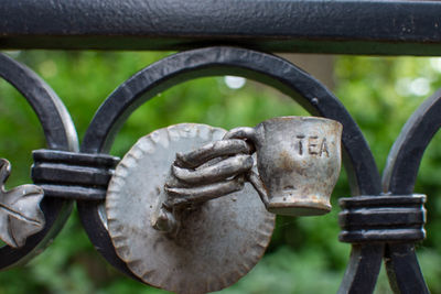 Close-up of rusty metal chain against fence