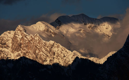 Low angle view of snowcapped mountains against sky