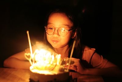 Portrait of woman holding lit candle