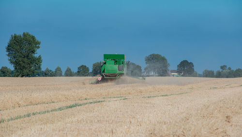 Combine harvester harvesting crops on agricultural field