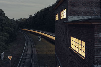 Blurred motion of train by building during sunset