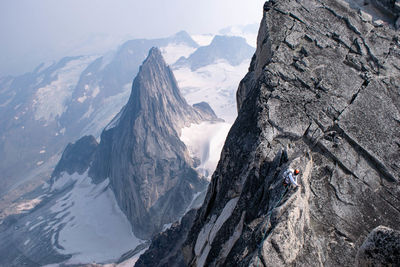 High angle view of young man climbing mountain during winter