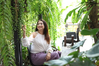 Smiling young woman sitting outdoors