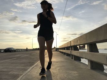 Full length of woman standing on bridge against sky