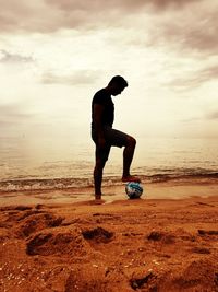 Man with ball on beach
