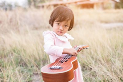 Portrait of cute girl playing on land