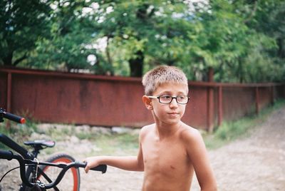 Portrait of shirtless boy with bicycle