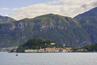 Scenic view of sea by mountains against sky