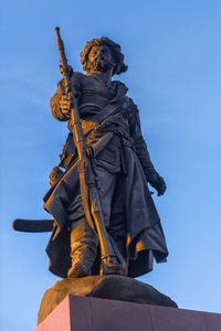 Low angle view of statue against blue sky