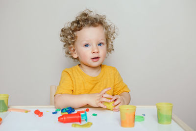 Caucasian baby boy child playing with sensor kinetic toy playdough. early age preschool education.