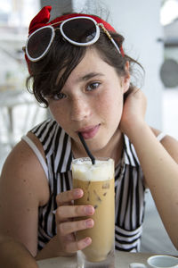 Close-up portrait of girl drinking iced coffee