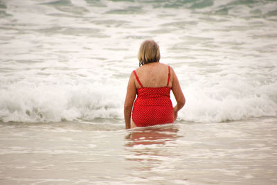 Rear view of boy swimming in sea