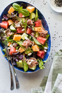 A fresh melon and prosciutto salad, ready for serving.