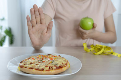 Midsection of man with fruits on table at home