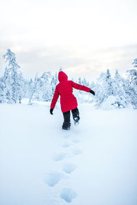 Rear view of person on snow covered field