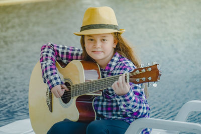Full length of a boy playing guitar