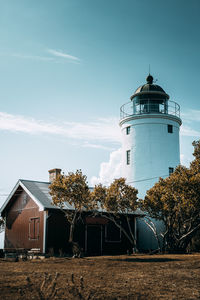 Lighthouse on field against sky