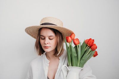 Portrait of woman wearing hat against white background