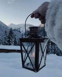 Person holding snow on mountain road during winter