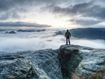 Man stay above heavy mist in deep valley. hike in pure nature is  activity in all of the world.