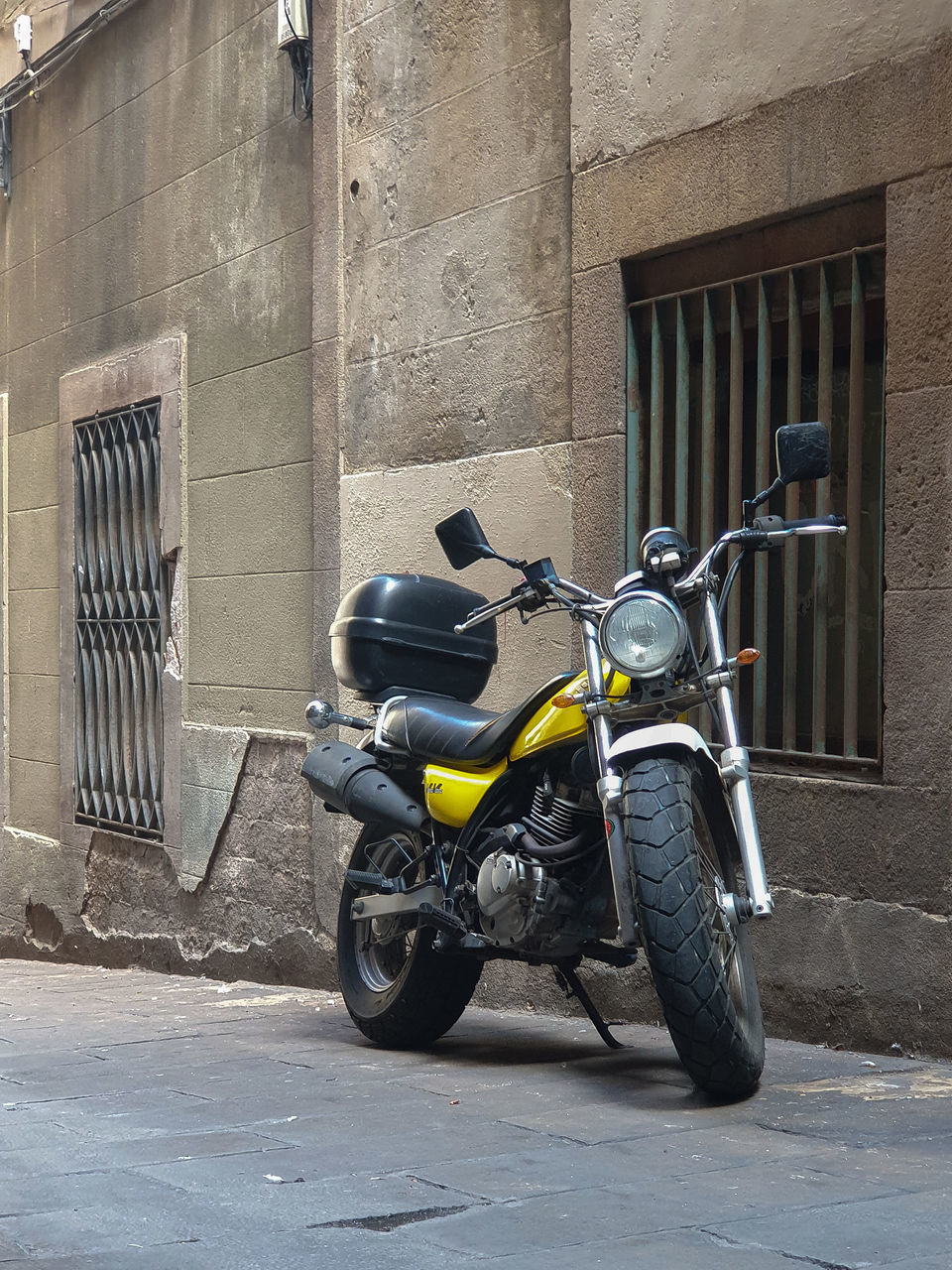 MOTORCYCLE PARKED ON STREET BY BUILDING