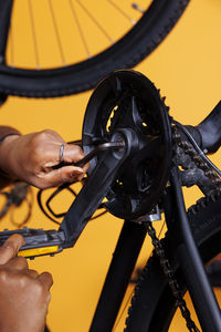 Cropped hand of man repairing bicycle