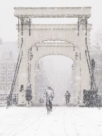 Rear view of people walking in snow