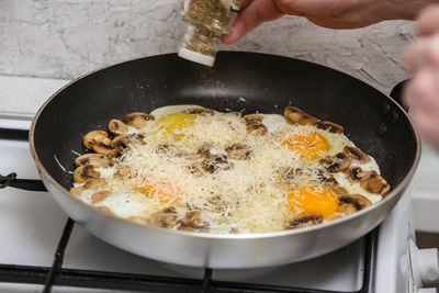 Close-up of person preparing food in pan