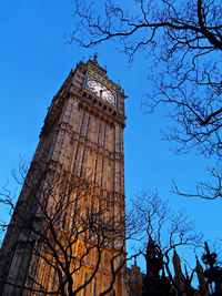 Low angle view of clock tower against blue sky