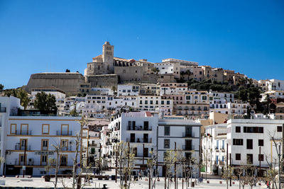 Low angle view of buildings against clear blue sky