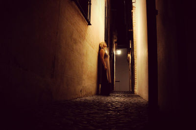 Woman standing in illuminated corridor