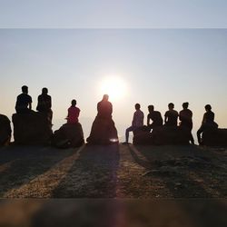 Group of people at beach during sunset