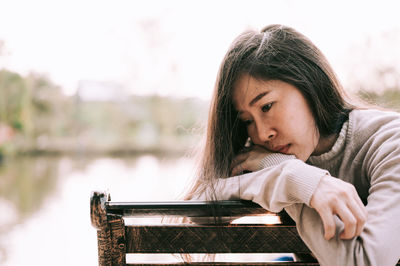 Portrait of young woman looking at lake