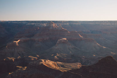 Scenic view of dramatic landscape against clear sky during sunset