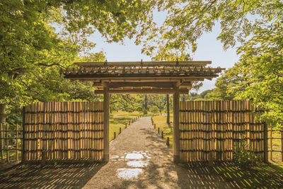 View of footpath leading to a bamboo gate in japanese park